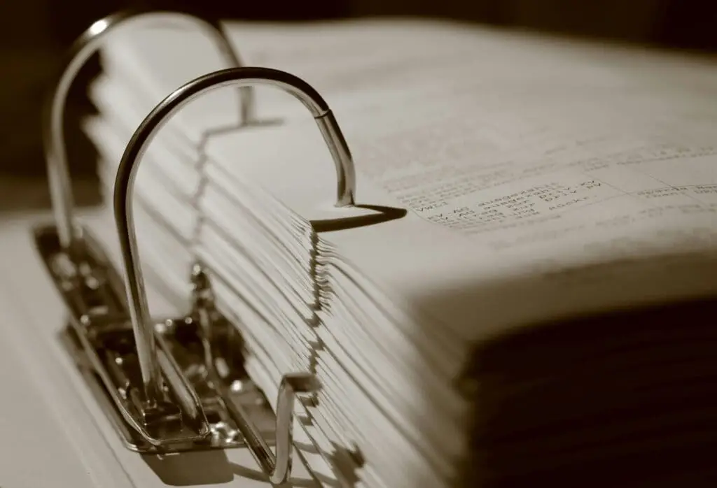Open ring binder with financial and legal documents for EB-5 project analysis